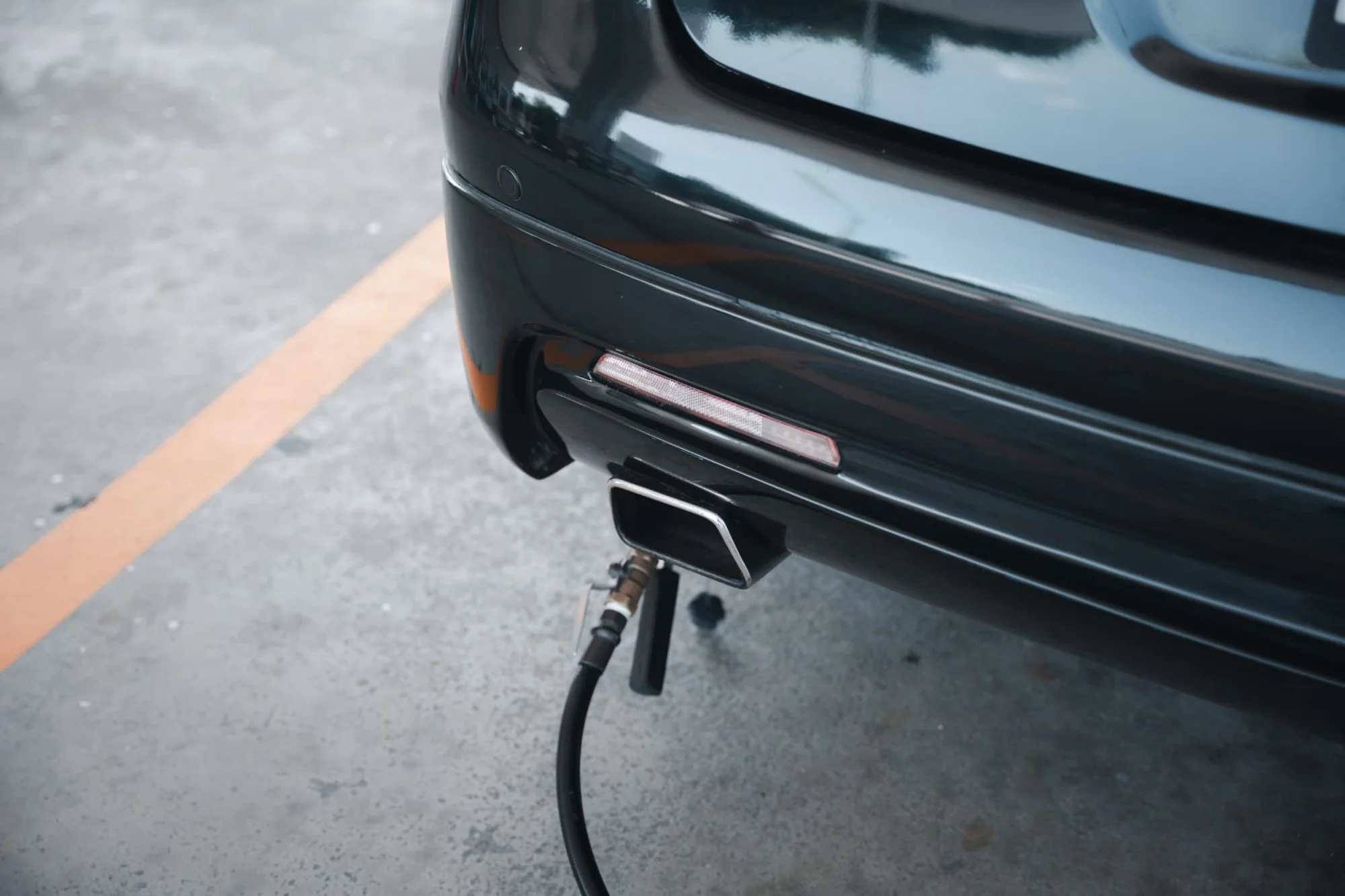 Probe checking a car exhaust during an emissions test